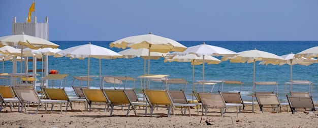 Italië, Sicilië, Middellandse Zee, Zuidelijke zandkust, Playa Grande (provincie Ragusa); 18 juni 2021, parasols en ligstoelen op het strand - REDACTIE