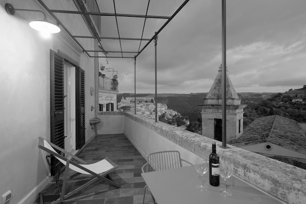 Foto italië, sicilië, ragusa ibla, uitzicht op een balkon van een oud huis en de barokke stad op de achtergrond bij zonsondergang