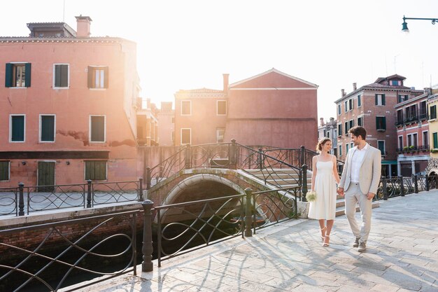 Italië, Venetië, bruidspaar hand in hand wandelen bij zonsopgang