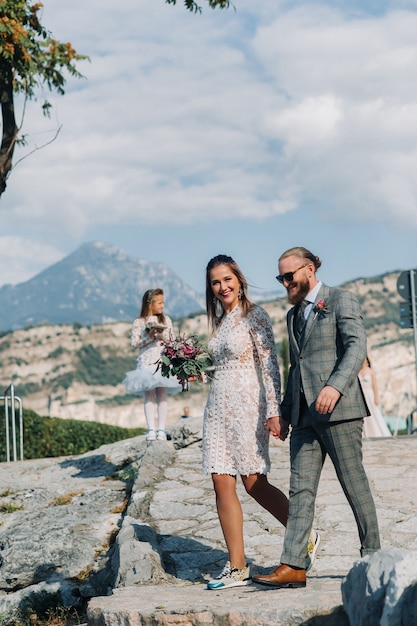 Italia, lago di garda. bella famiglia sulle rive del lago di garda in italia, ai piedi delle alpi. padre, madre e figlia in italia.