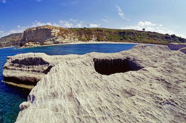 イタリア、地中海、カラブリア、ブリアティコ。ローマ人がウツボの水産養殖のためにバスクを彫った聖イレーネ岩の眺め (FILM SCAN)