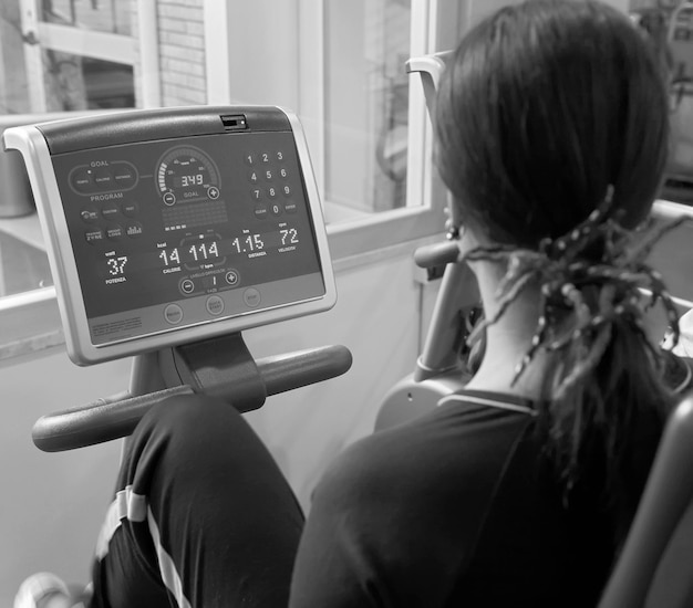 Italy, Rome, woman on a cyclette in a fitness center