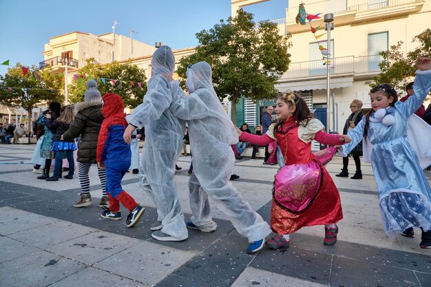 イタリア、シチリア島、マリーナ ディ ラグーザ (ラグーザ県)。 2019年3月2日、町の中央広場でカーニバルで遊ぶ子供たち - 社説