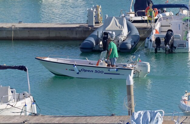 Italy, Sicily, Mediterranean Sea, Marina di Ragusa (Ragusa Province); 31 October 2020, fisherman on a motor boat in the port - EDITORIAL