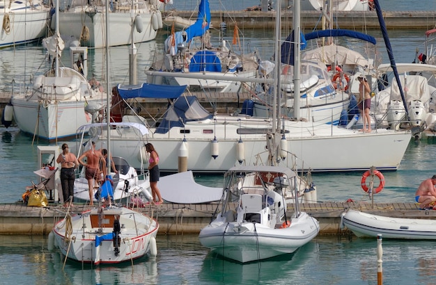 Foto italia sicilia mar mediterraneo marina di ragusa provincia di ragusa 9 luglio 2023 uomini su una barca a vela e yacht di lusso nel porto editorial