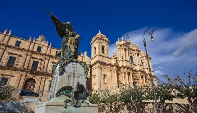 Italy, Sicily, Noto (Siracusa Province), view of  a bronze statue and the S. Nicolò Cathedral baroque facade (1703)