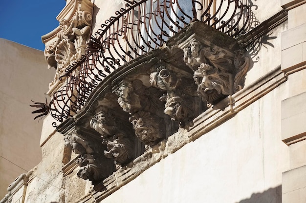 이탈리아, 시칠리아, 라구사 이블라, 코센티니 궁전(유네스코 기념물)의 바로크 양식의 외관, 발코니 아래 장식용 조각상