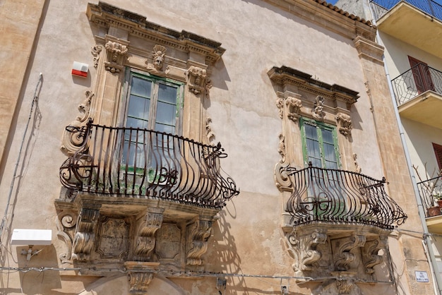 Italy, Sicily, Scicli (Ragusa province), the Baroque facade and balconies of an old building