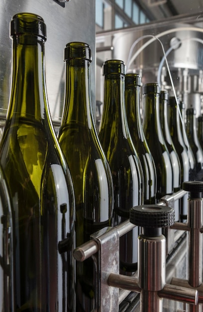 이탈리아 시칠리아 와인 병은 와인 공장의 산업 기계에 의해 세척되고 와인으로 채워질 준비가 되어 있습니다