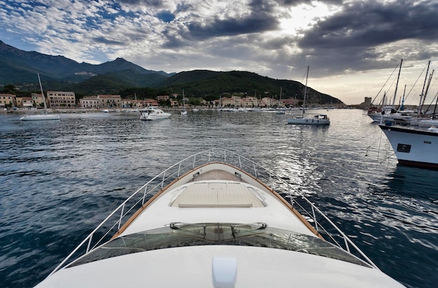 Italy Tuscany Elba Island entering the port of Marciana Marina town with a luxury yacht Azimut 75'