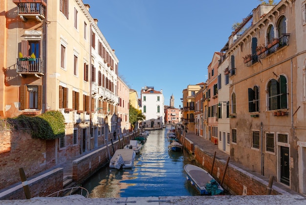 イタリアヴェネツィア2017年2月25日色とりどりの家がたくさんのボートと晴れた朝の橋があるヴェネツィア通り