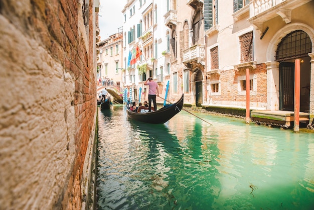 Italy Venice May 25 2019 people at gondola taking tour by canal summer vacation