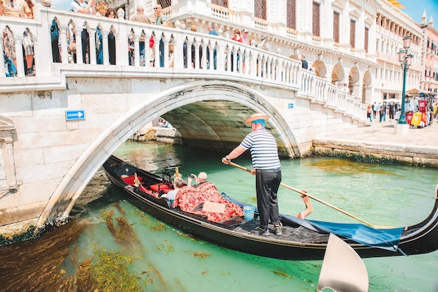 Italy Venice May 25 2019 people at gondola taking tour by canal