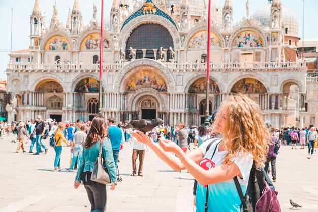 写真 イタリアヴェネツィア2019年5月25日サンマルコ広場の観光客の女性と鳩