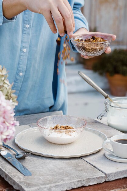 Italy, woman preparing breakfast on terrace, partial view