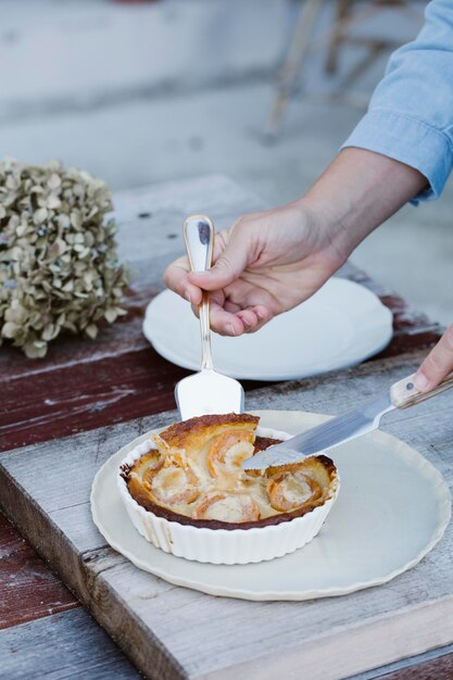 Italy, woman taking piece of tartlet, partial view