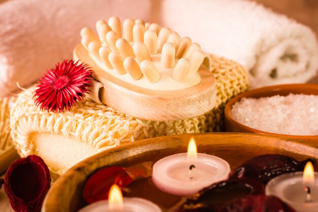 Items for spa treatments. Candles and fragrant dried flowers in water, sea salt, massager and towels