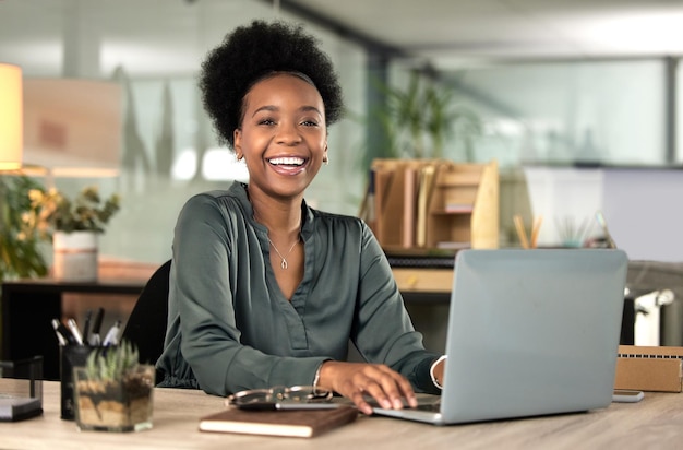 Its about putting in the work. Cropped portrait of an attractive young businesswoman working on her laptop in the office.