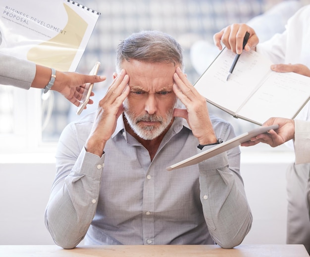 Its all just a little too much Cropped shot of a handsome mature businessman looking stressed while being presented with multiple tasks at his desk in the office