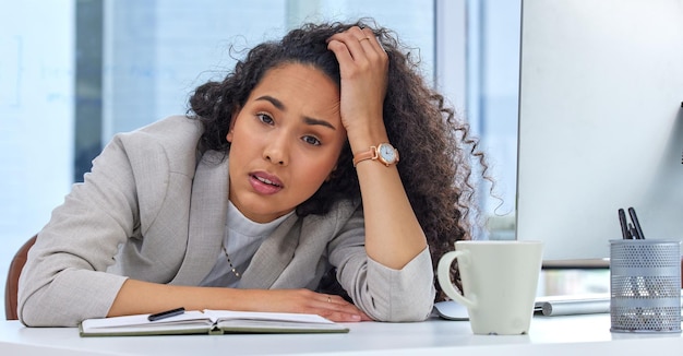 Its been a crazy day Shot of a young businesswoman looking stressed out while working in an office