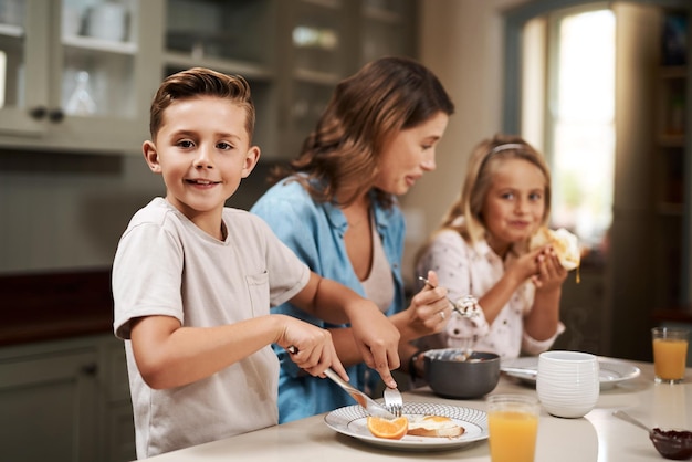 その朝食時間家で朝食をとっている若い家族のトリミングされたショット