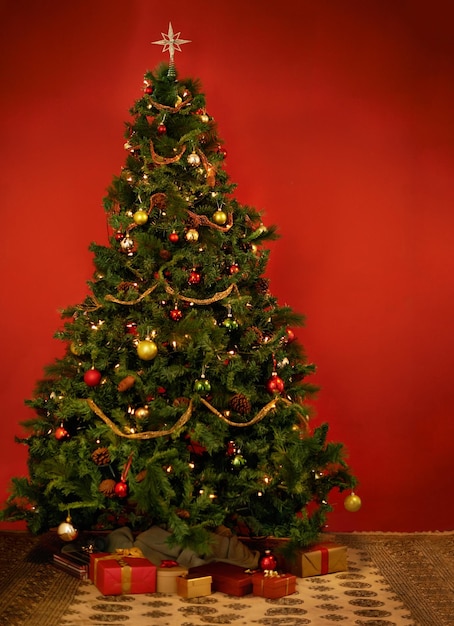 Its Christmastime Studio shot of a decorated Christmas tree with gifts underneath it