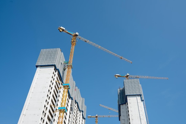 È una bella giornata con il cielo blu e la gru a torre sui grattacieli della città è in costruzione