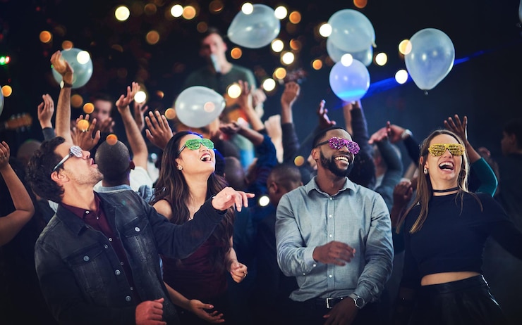 Photo its going down cropped shot of a diverse group of young friends having fun with balloons at a party at night