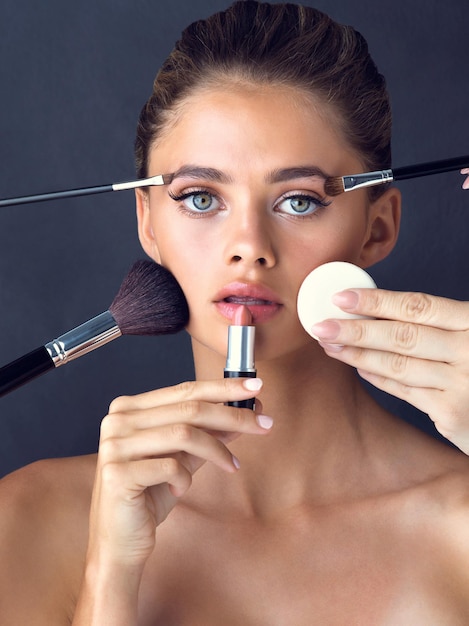 its hard work to maintain good looks studio shot of an attractive young woman posing while cosmetics are applied on her face