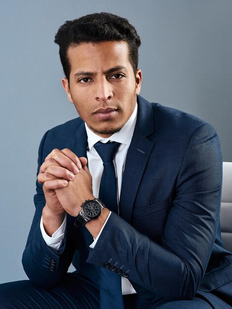 Its just business to him Studio shot of a corporate businessman posing against a grey background