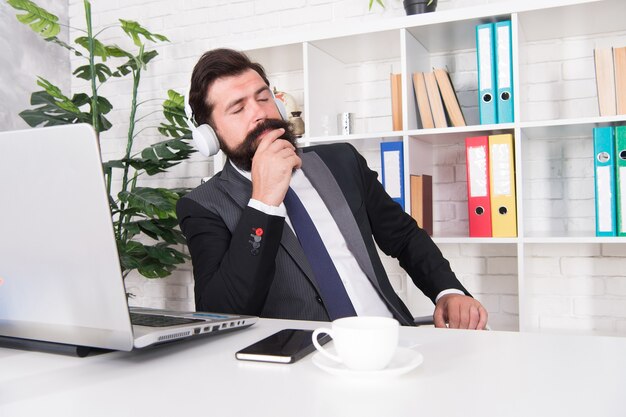 Its okay to have break. Bearded man listen to music at work break. Businessman relax during break time. Manager in formal suit enjoy rest break. Rest and timeout. Music and relaxation. Take it easy.