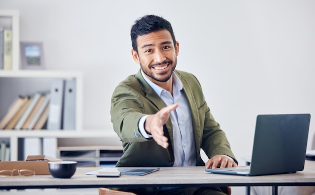 Its a pleasure to meet you. Cropped shot of a handsome young businessman gesturing for a handshake while sitting in his office.