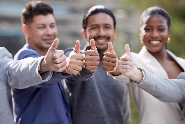 Its a yes from us Portrait of a group of businesspeople showing a thumbs up outside