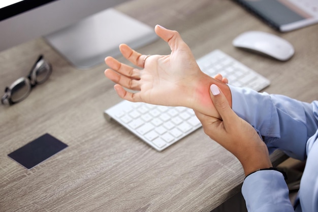 Ive been working without a break for too long. Cropped shot of an unrecognisable businesswoman sitting alone in the office and suffering from wrist pain.