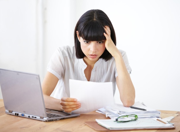 Ive gone way over budget A shocked businesswoman reading the financial breakdown of her budget