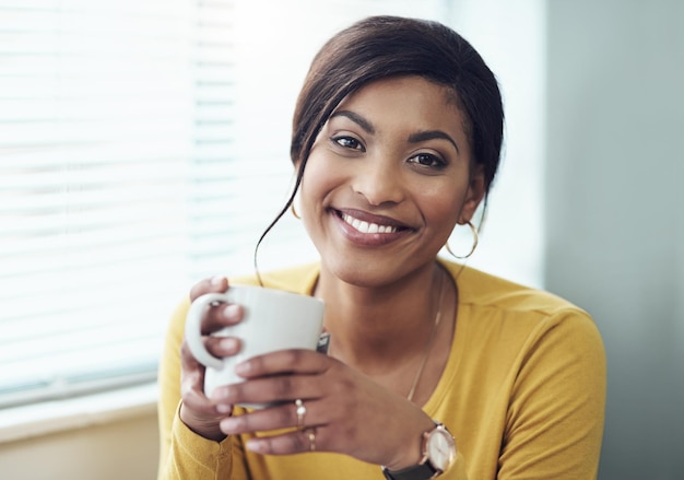 私は私のお気に入りのお茶を手にしています 魅力的な若い女性が一人で家に座ってコーヒーを飲んでいるショット