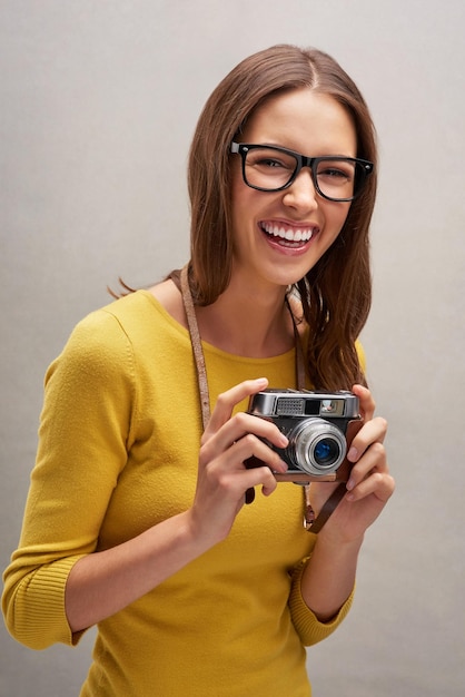 Ive got some great shots Studio portrait of an attractive young female photographer posing with her camera against a grey background