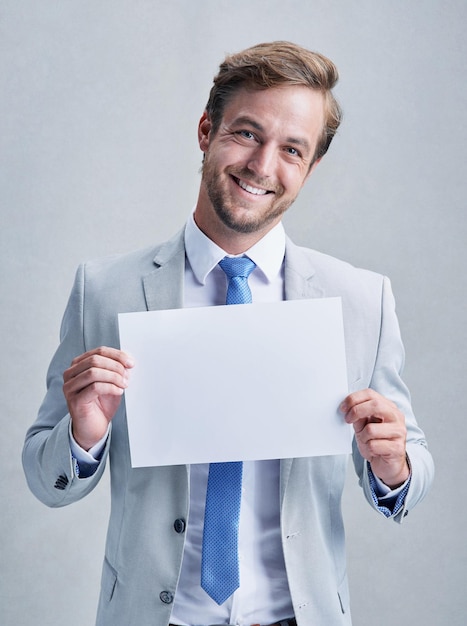 Ive some good news for you Studio shot of a businessman in a grey suit posing against a grey background