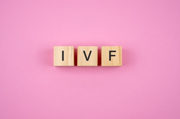 IVF-tekst op houtblok roze achtergrond