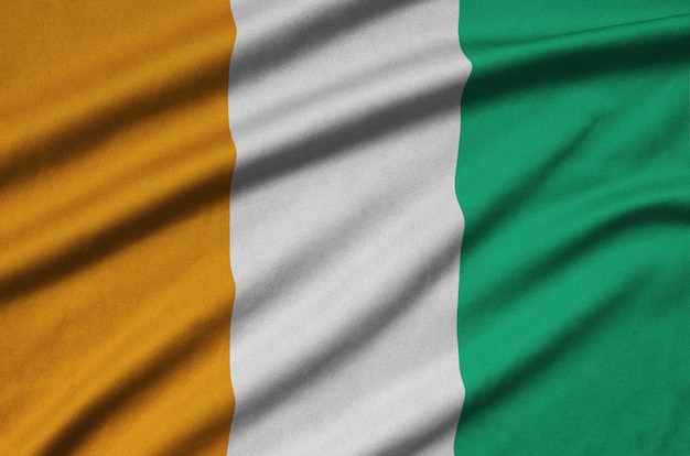 Ivory Coast flag  is depicted on a sports cloth fabric with many folds.