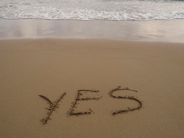 Ja geschreven in zand op zee strand textuur