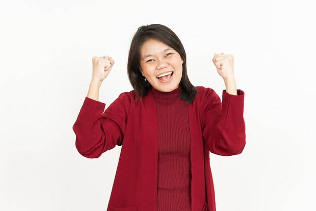 Ja opgewonden gebaar van mooie Aziatische vrouw die rood overhemd draagt dat op witte achtergrond wordt geïsoleerd