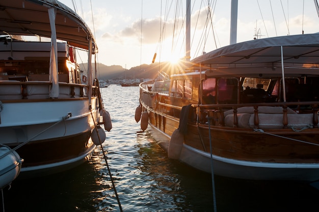 Jachten op de pier tegen de achtergrond van een prachtige zonsonderganghemel met zonnestralen