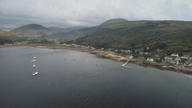 Jachten schepen op groene berg op oceaan baai kust luchtfoto niemand natuur met serene zeegezicht water