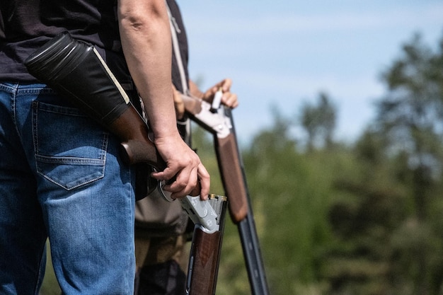 Foto jachtgeweer afvuren jagen in het bos jager laadt pistool met kogels een geweer in een close-up van de hand van een man