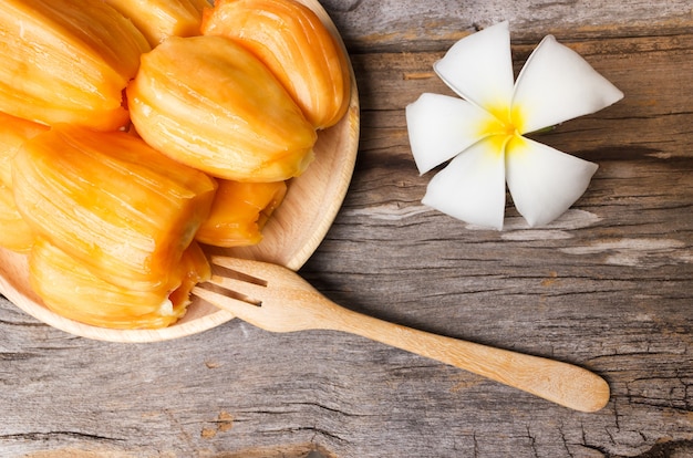 Jack fruit in houten plaat op oude houten achtergrond.