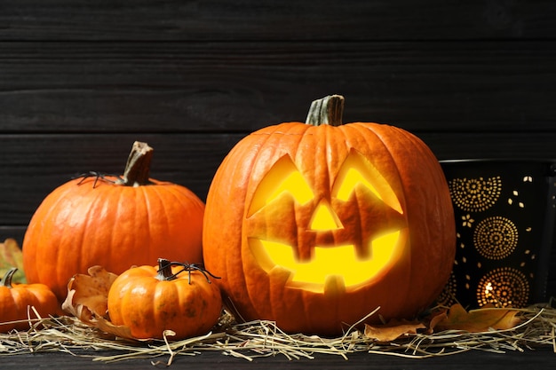 Jack o'lantern pompoenen en stro op zwarte houten tafel Halloween decor