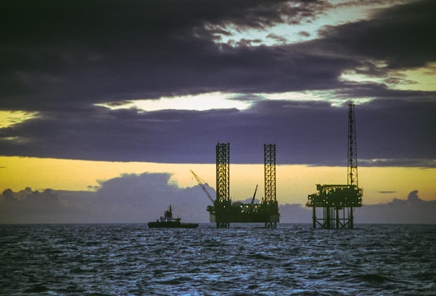 Foto una piattaforma petrolifera jack-up che viene manovrata in posizione accanto a una piattaforma di gas nel sud del mare del nord