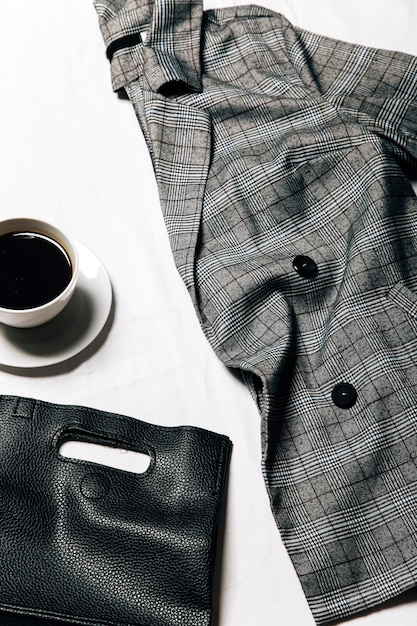 a jacket coffee and a bag on the bed  stylish image