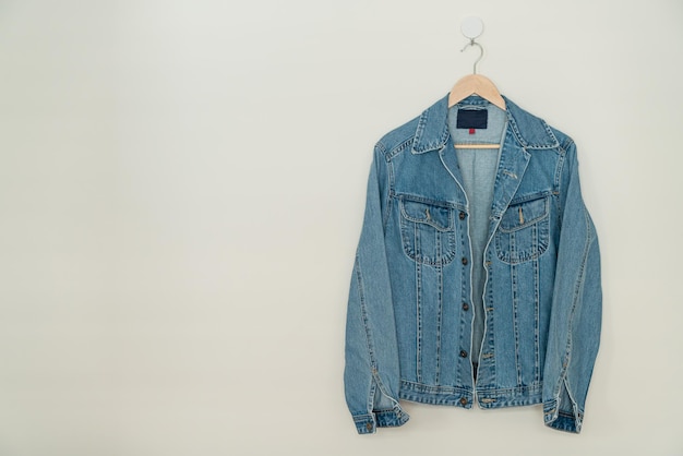 Photo jacket jean hanging with wood hanger on wall